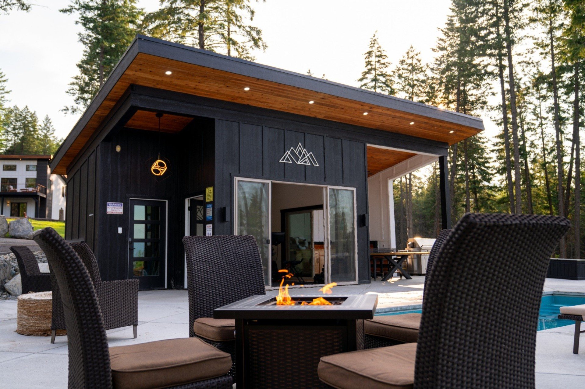 Fire pit glowing in the evening beside the estate pool house