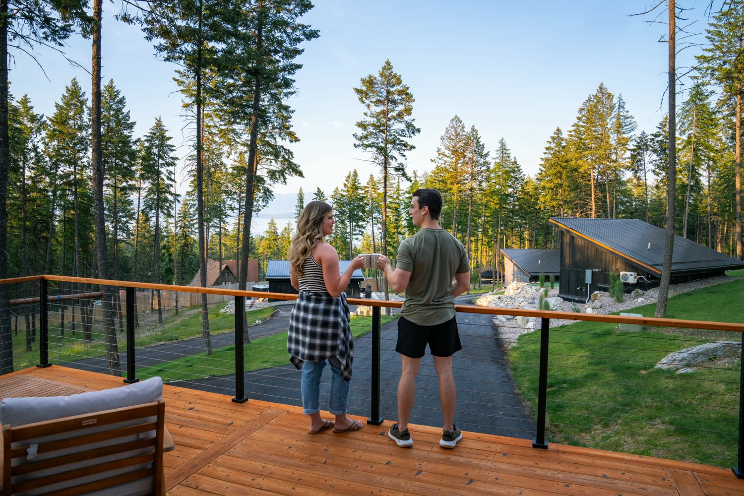Two guests on the upper deck at The Swan House, looking out over the pines and the estate below